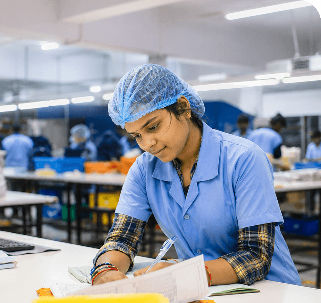 Operator filling in production records by hand on the factory floor