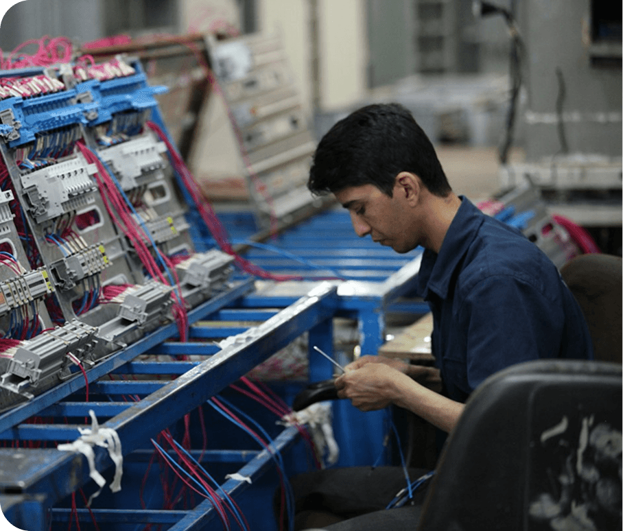 Supervisor checking production on a tablet beside copper wire coils