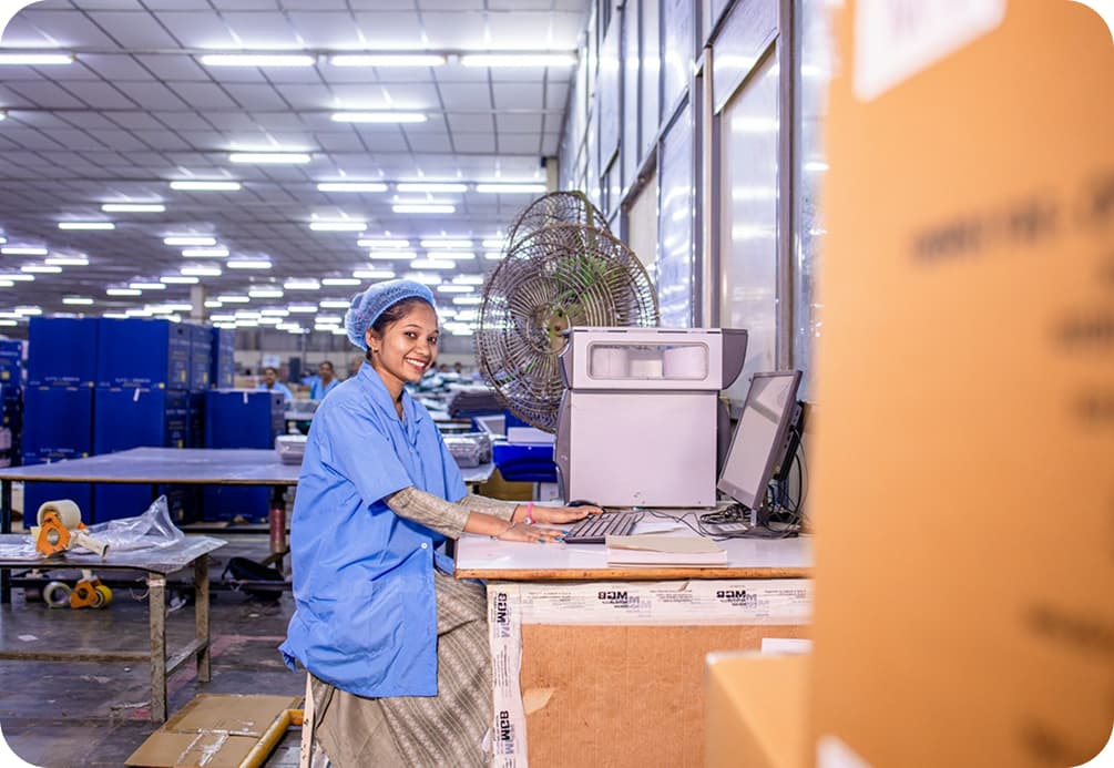 Accountant working on a laptop at a desk on the factory floor
